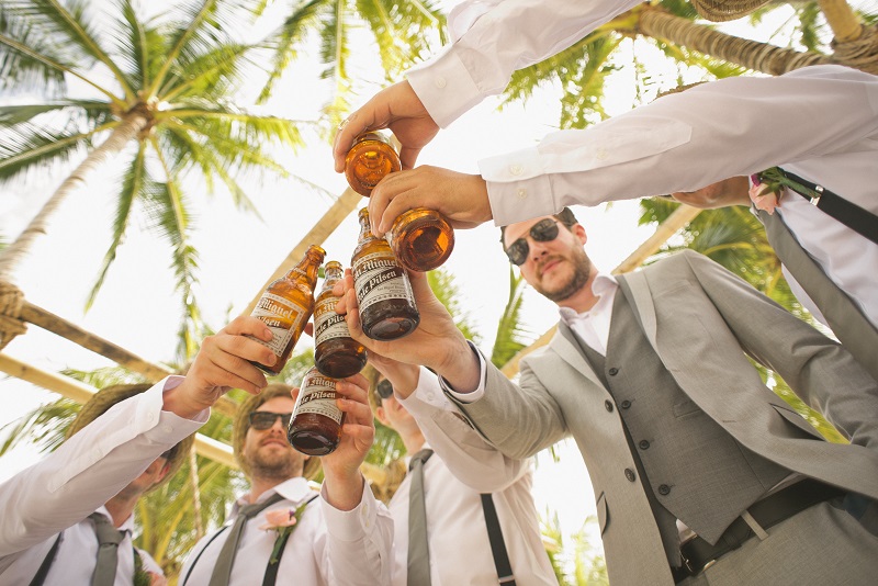 Groomsmen toasting with beer at wedding