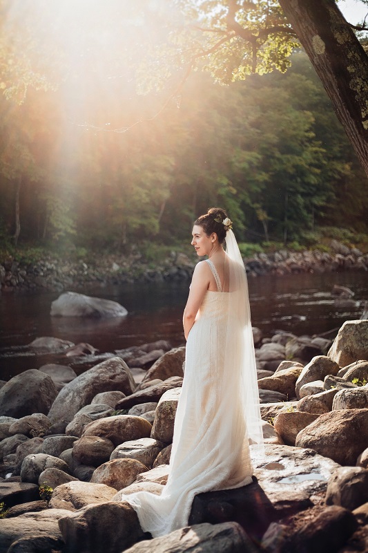 Bride standing in front of river