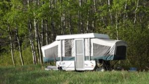 pop-up camper set up in the forest