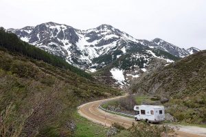 white RV driving on a mountain road