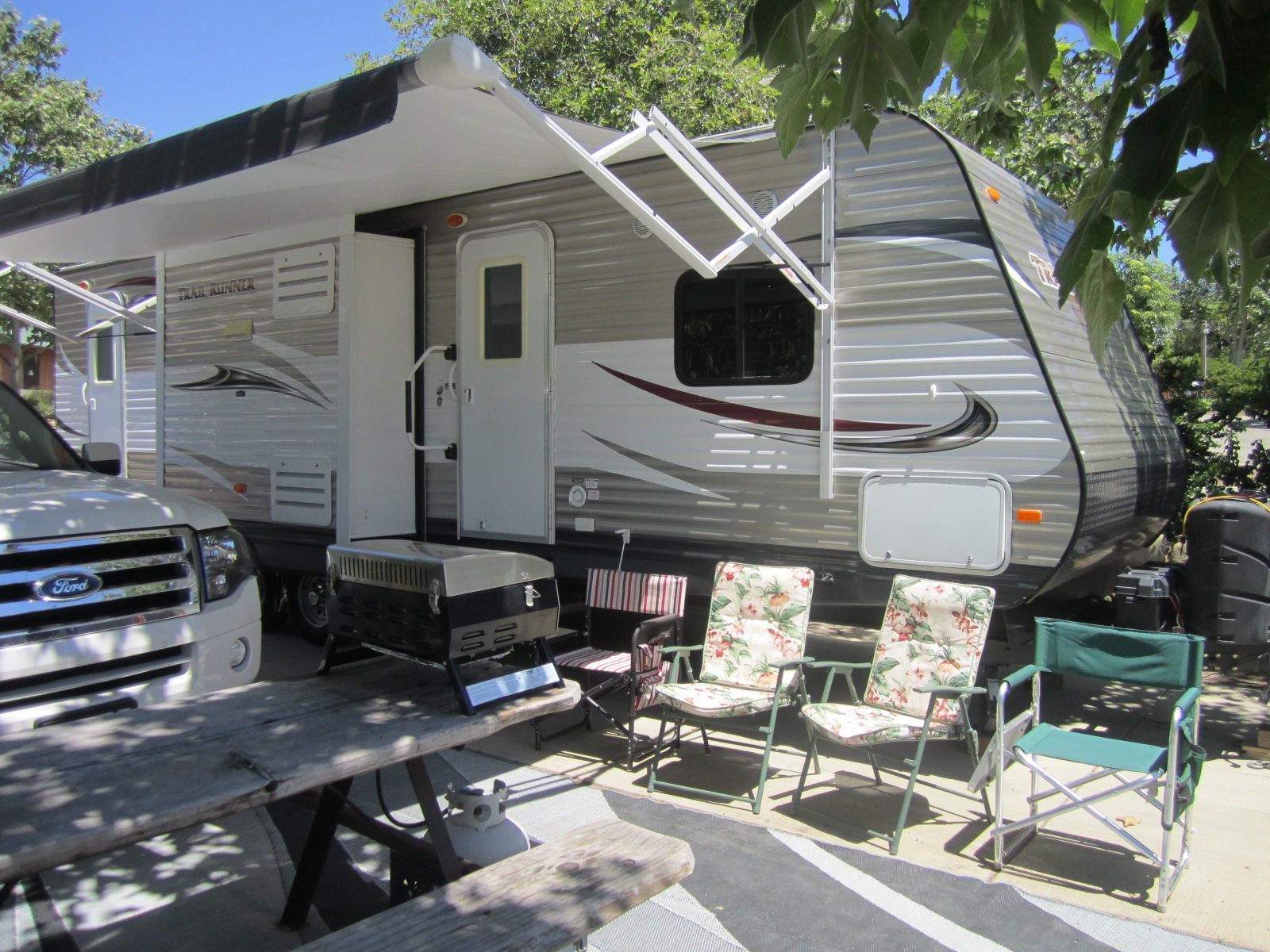 RV rental set up next to camping chairs