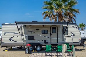 RV parked next to green camp chairs