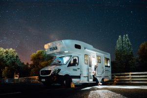 white RV parked with lights on