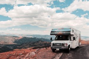 white RV parked underneath a cloudy sky