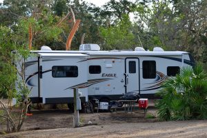 white RV rental delivered and set up at a campground