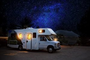 white RV camping under a night sky