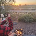 Girl taking photo of sunset