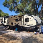 white RV delivered and set up at a campground